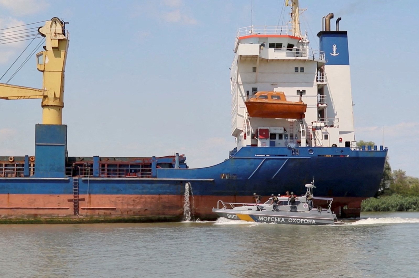 A cargo ship sails followed by a Ukrainian Coast Guard cutter through the Bystre rivermouth, which connects the Black Sea and Danube, at a location given as Izmail district of Odesa region, Ukraine, July 15, 2022. (Reuters Photo)