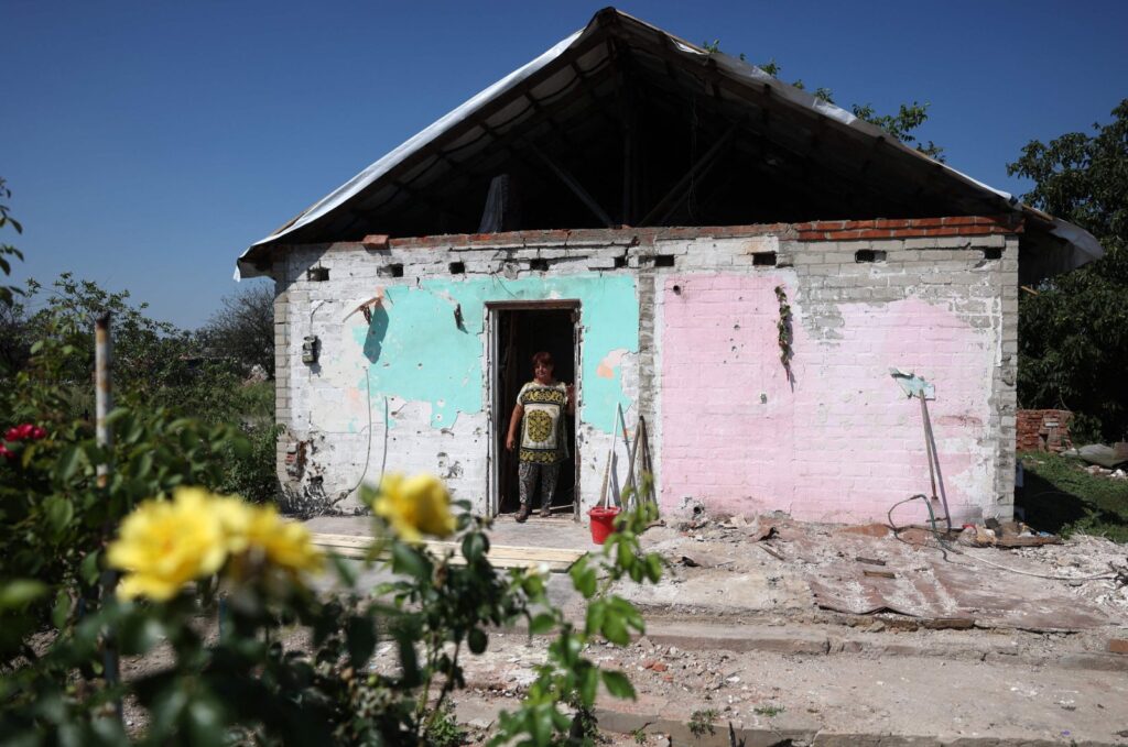 A local resident looks out from her damaged house in Topol's'ke village, Kharkiv region, Aug. 5, 2023. (AFP Photo)