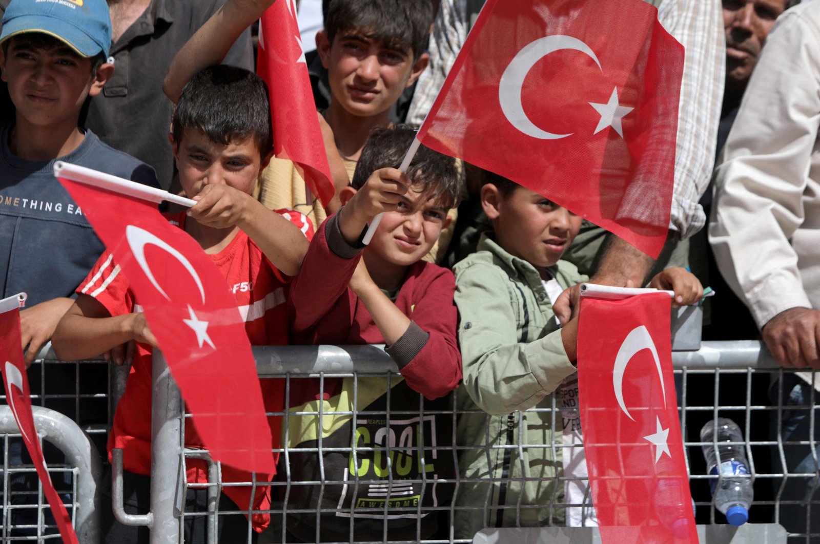 Syrian children wave Turkish flags as they attend the inauguration of a Qatari-funded Turkish housing complex project for the internally displaced, Ghandoura area, Jarablus, Syria, May 24, 2023. (AFP Photo)