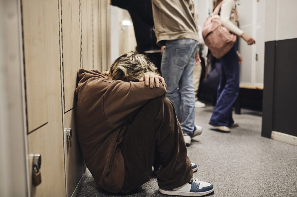 Sad teenage girl sitting in a school corridor in this undated file photo. (Getty Images File Photo)