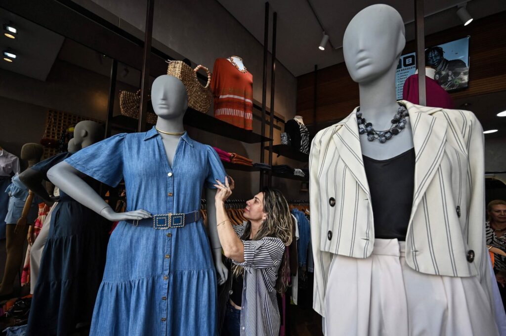 A sales staff dresses a plus size mannequin at a store in Sao Paulo, Brazil, Aug. 4, 2023. (AFP Photo)