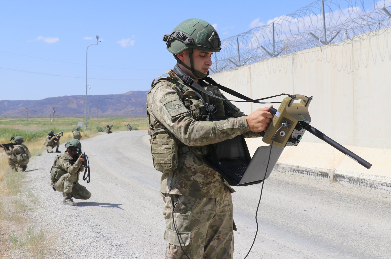 A guard near the wall dividing the Turkish-Iranian border scans the area via drone footage for illegal crossings, Van, eastern Türkiye, Aug. 16, 2023. (AA Photo)