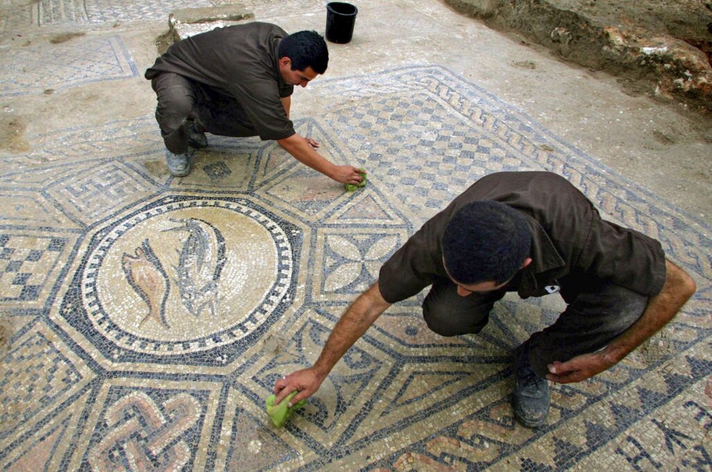 Prisoners work at a nearly 1,800-year-old decorated floor from an early Christian prayer hall discovered by Israeli archaeologists, Israel, Aug. 13, 2023. (AP Photo)