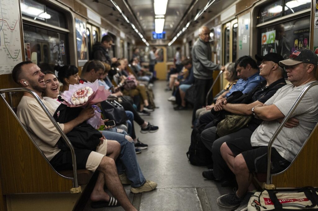 A couple share a laugh in a subway car, Kyiv, Ukraine, July 8, 2023. (AP Photo)