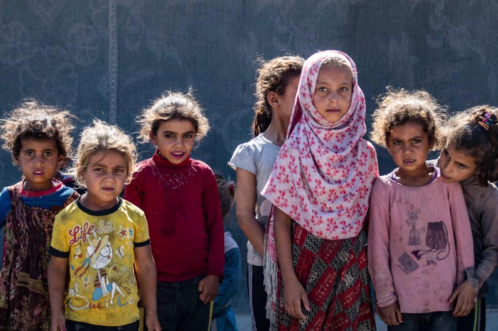 Girls stand next to a tent at the al-Yunani makeshift camp for thousands of internally displaced people who are largely cut off from international assistance in Syria's northern province of Raqqa, July 10, 2023. (AFP Photo)