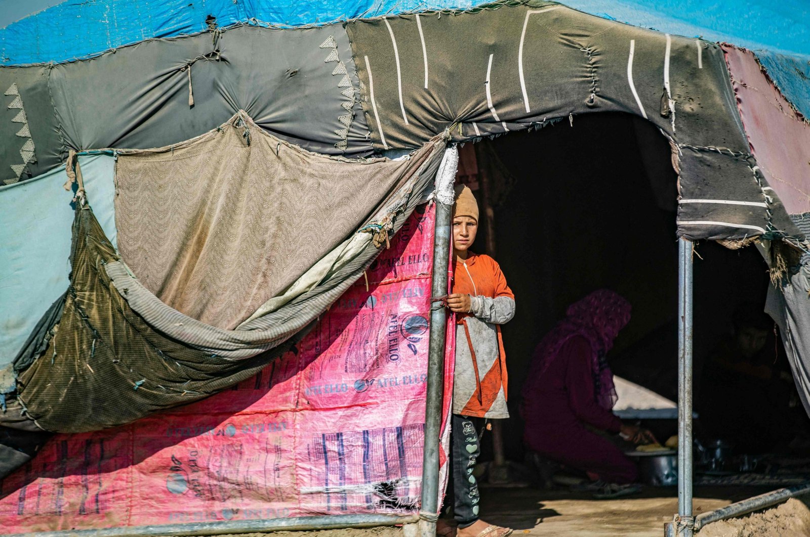 A child stands at her tent's entrance at the al-Yunani makeshift camp for thousands of internally displaced people who are largely cut off from international assistance in Syria's northern province of Raqqa, July 10, 2023. (AFP Photo)