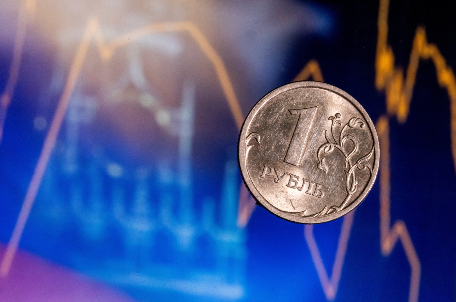 A view of one Russian rouble coin in front of a screen displaying the Spasskaya tower of Moscow Kremlin in an illustration picture, Aug. 22, 2023. (Reuters Photo)