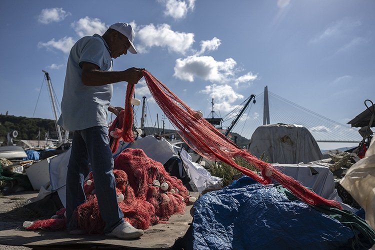 A fisherman loads a net on a boat, Istanbul, Türkiye, Aug. 27, 2023. (AA Photo)