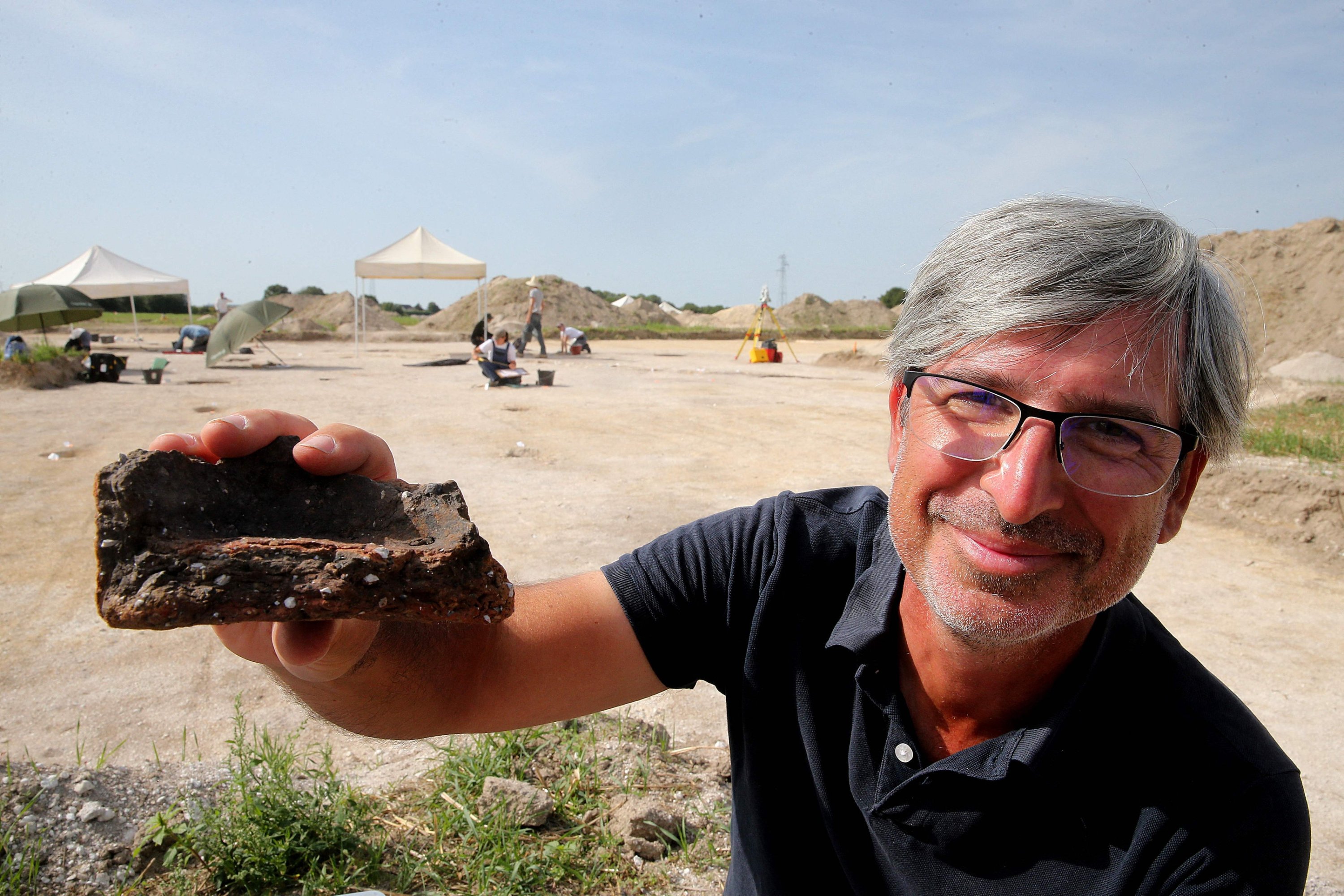 289362 Remi Martineau, researcher at the CNRS, holds up a fragment of pottery dating from the Modern Neolithic, around 3500-years-ago, from a settlement suggesting the presence of a village occupied by a structured population, at Val-des-Marais, France, Aug. 23, 2023. (AFP Photo)