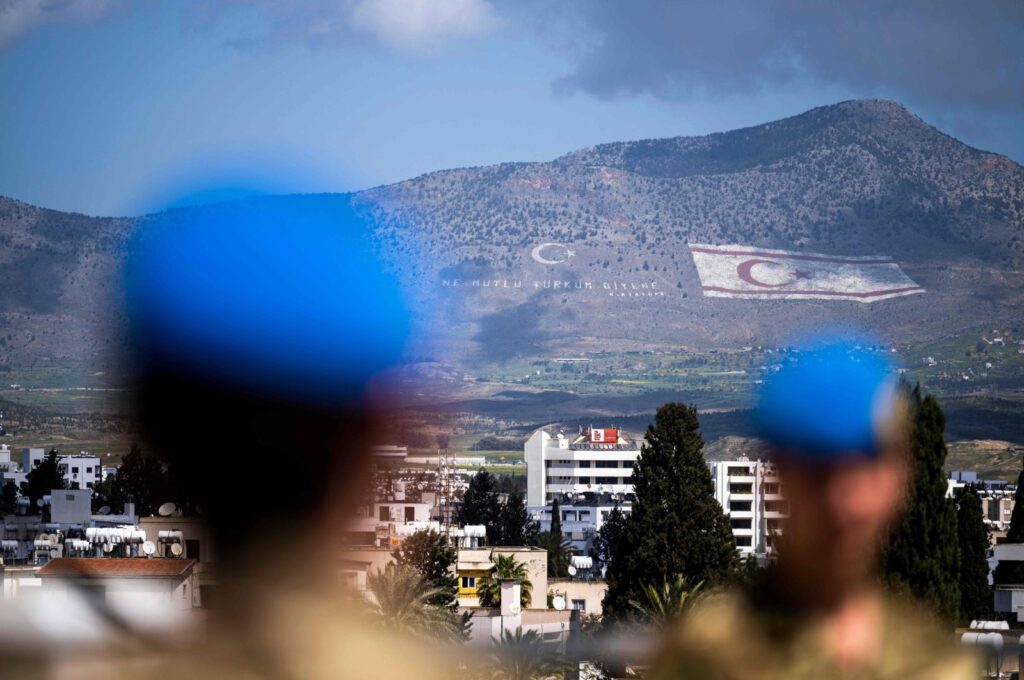 Members of the United Nations Peacekeeping Force in Cyprus (UNFICYP) from the British Household Cavalry Regiment visit the roof of the Ledra Palace in the U.N. buffer zone separating the divided capital of Nicosia; while the flag of the Turkish Republic of Northern Cyprus (TRNC) painted on the island's northern Kyrenia mountain range lies in the background, on April 5, 2023.