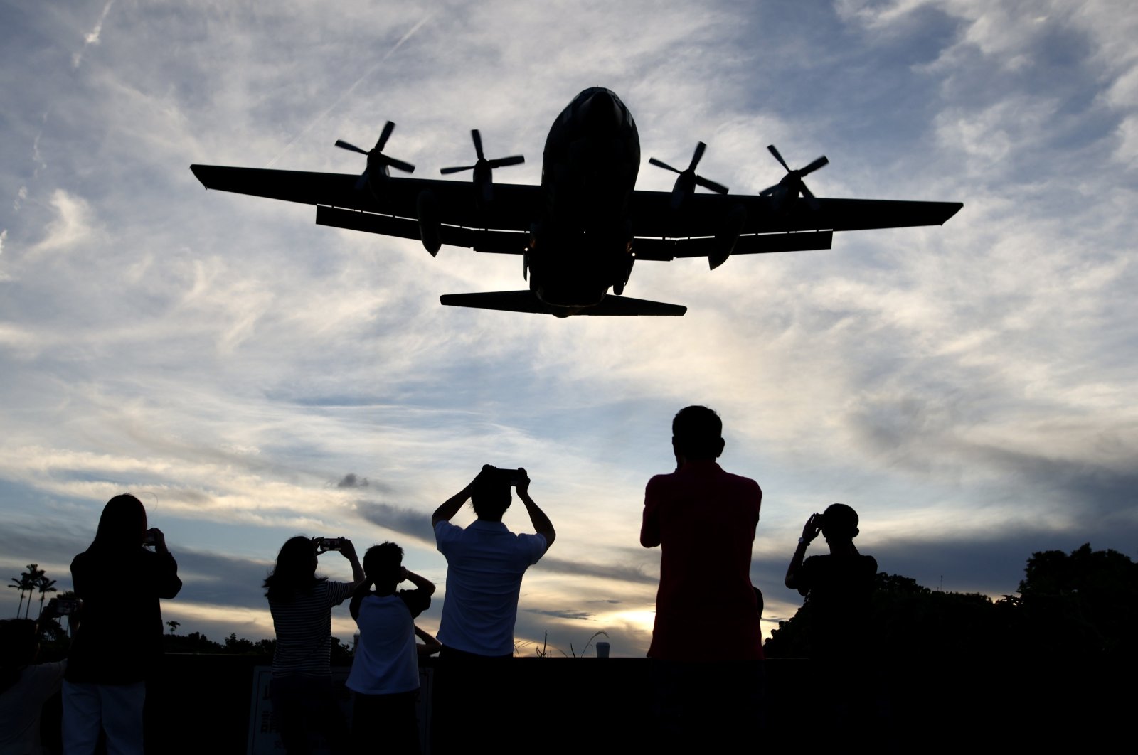 People photograph an approaching Taiwan C-130 Hercules Military plane at Songshan airport, in Taipei, Taiwan, Aug. 25, 2023. (EPA Photo)