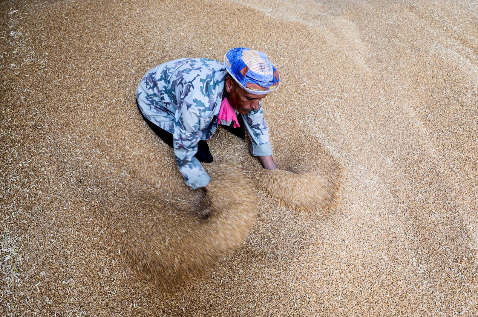 A worker collects wheat at the Benha grain silos in Al Qalyubia Governorate, Egypt, May 19, 2022. (Reuters Photo)