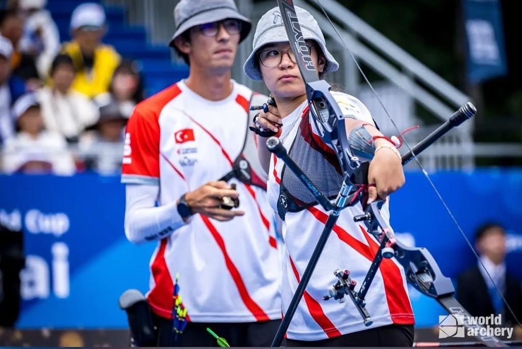 Fatma Maraşlı (R) shoots an arrow in from of Mete Gazoz during the Archery World Cup, Shanghai, China, Aug. 14, 2023. (IHA Photo)