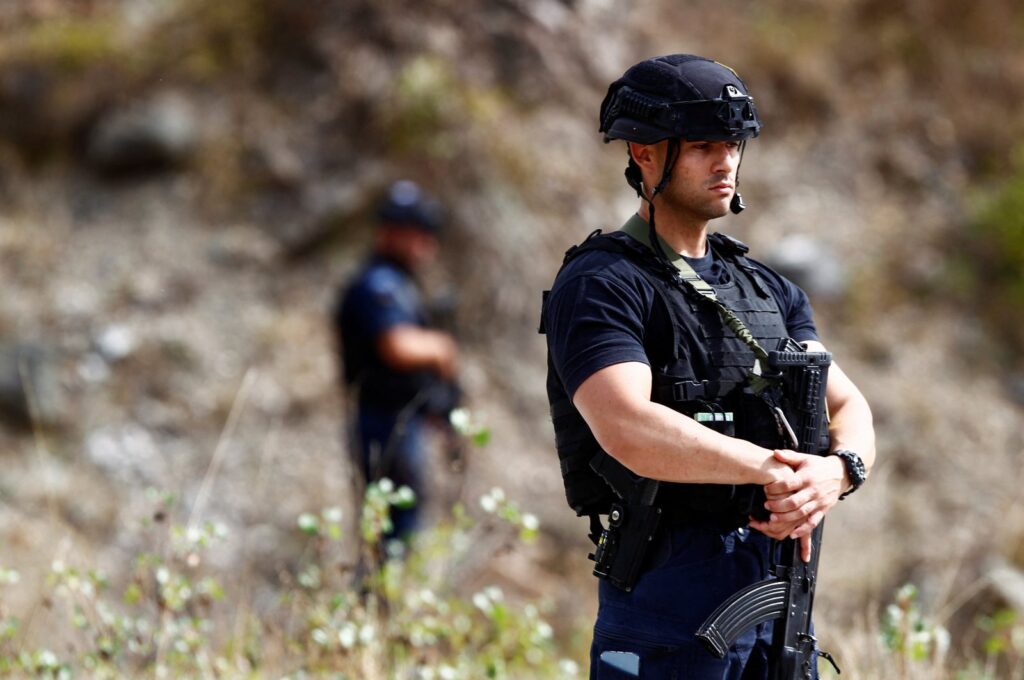 A police officer stands guard in the aftermath of a shooting, near the village of Zvecane, Kosovo September 24, 2023. (Reuters Photo)