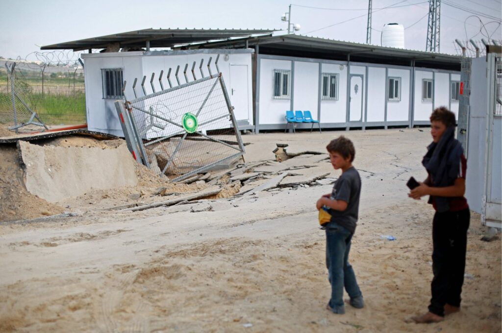 Youths stand by a crater following an Israeli airstrike at the Erez crossing between Israel and the northern Gaza Strip, Palestine, Oct. 7, 2023. (AFP Photo)