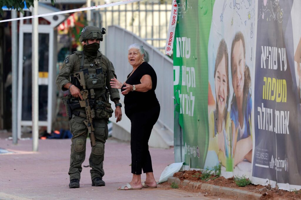 A resident stands with an Israeli soldier near a cordoned-off Israeli police station near the blockaded Gaza Strip, Palestine, Oct. 8, 2023. (AFP Photo)