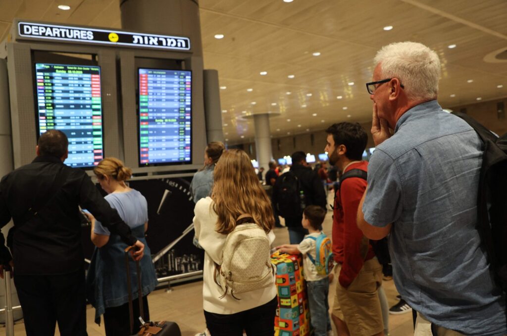 Passengers look at a departure board at Ben Gurion Airport as flights are canceled because of Hamas' surprise attacks, in Tel Aviv, Israel, Oct. 7, 2023. (AFP Photo)