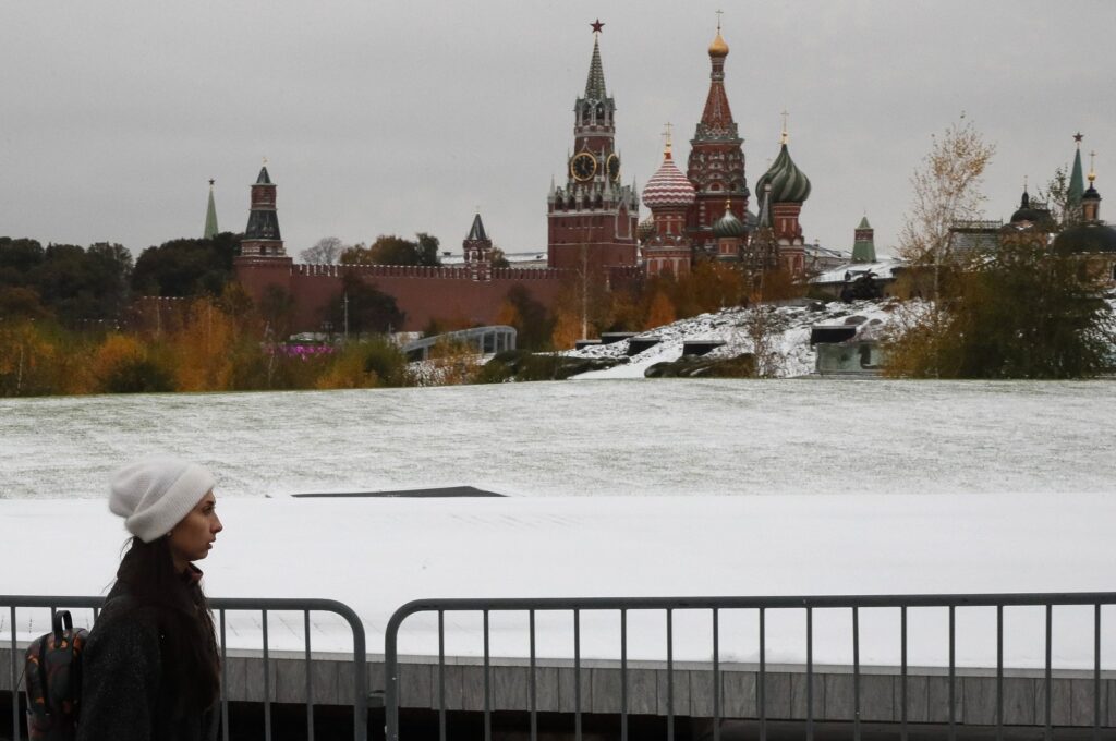 A woman walks along a snow-covered place in front of the Kremlin (background) after the first snowfall in Moscow, Russia, Oct. 27, 2023. (EPA Photo)