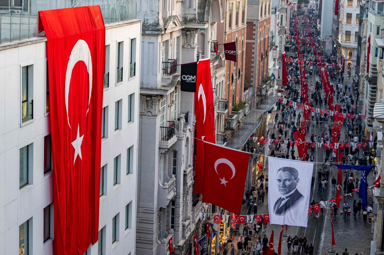 Turkish national flags and a banner depicting Mustafa Kemal Ataturk, the founding father of the Republic of Türkiye, are displayed on Istiklal Avenue, during celebrations to mark the 100th anniversary of the Turkish Republic, in Istanbul, Türkiye, Oct. 29, 2023. (AFP Photo)