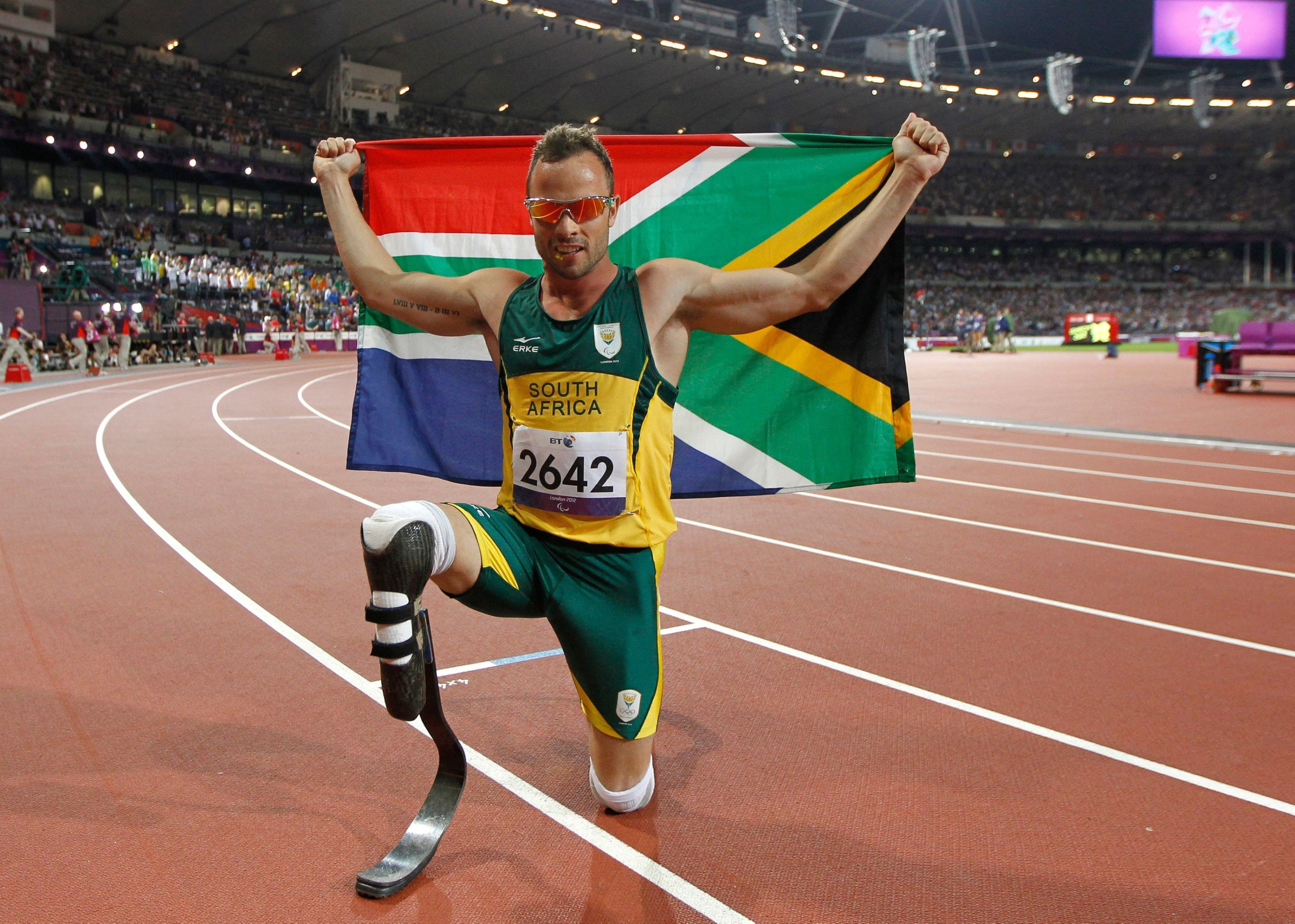 302559 South Africa's Oscar Pistorius poses with photographs with a national flag after winning gold in the men's 400m - T44 final during the athletics competition at the London 2012 Paralympic Games at the Olympic Stadium, London, U.K., Sept. 8, 2012. (AFP Photo)