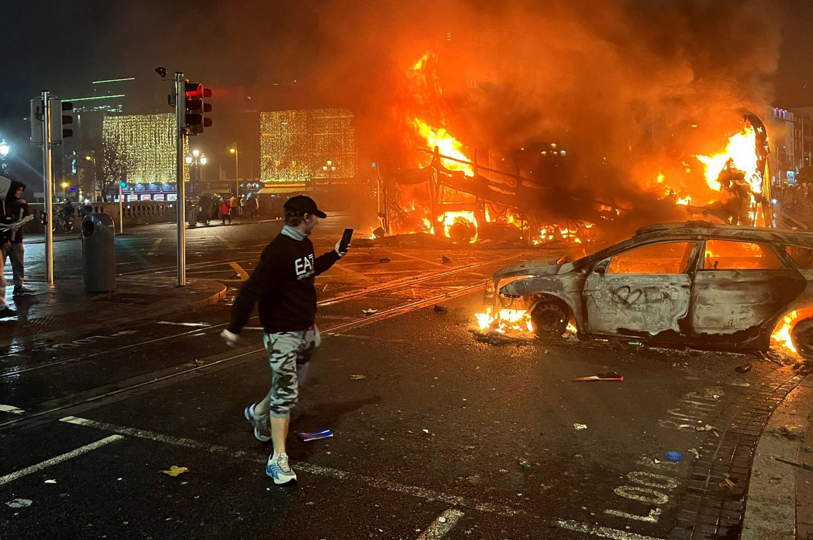Flames rise from a car and a bus, set alight at the junction of Bachelors Walk and the O'Connell Bridge, Dublin, Ireland, Nov. 23, 2023. (AFP Photo)