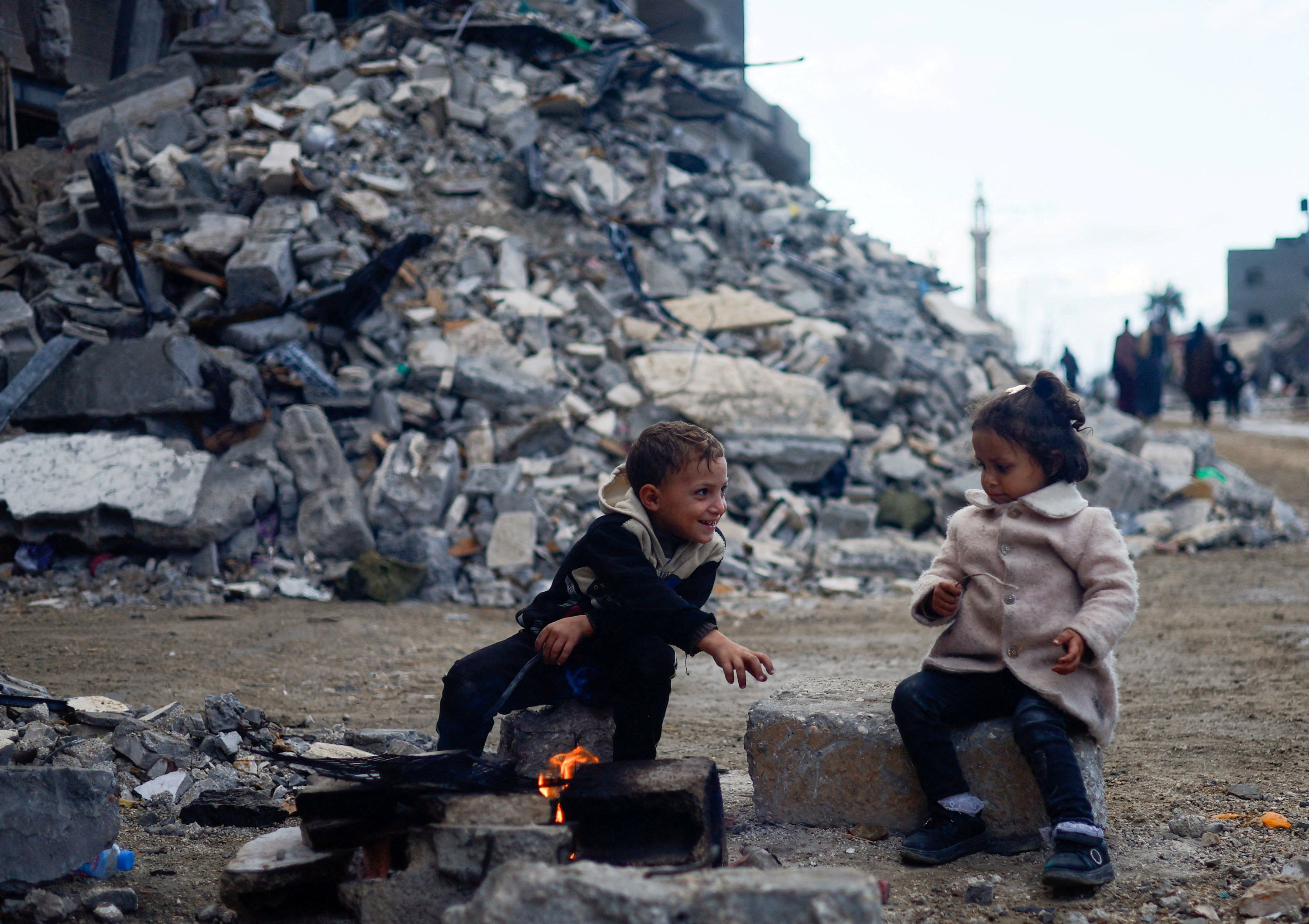 303194 Palestinian children sit by the fire next to the rubble of a house hit in an Israeli strike during the conflict, amid a temporary truce between Hamas and Israel, Khan Younis, southern Gaza Strip, Nov. 27, 2023. (Reuters Photo)