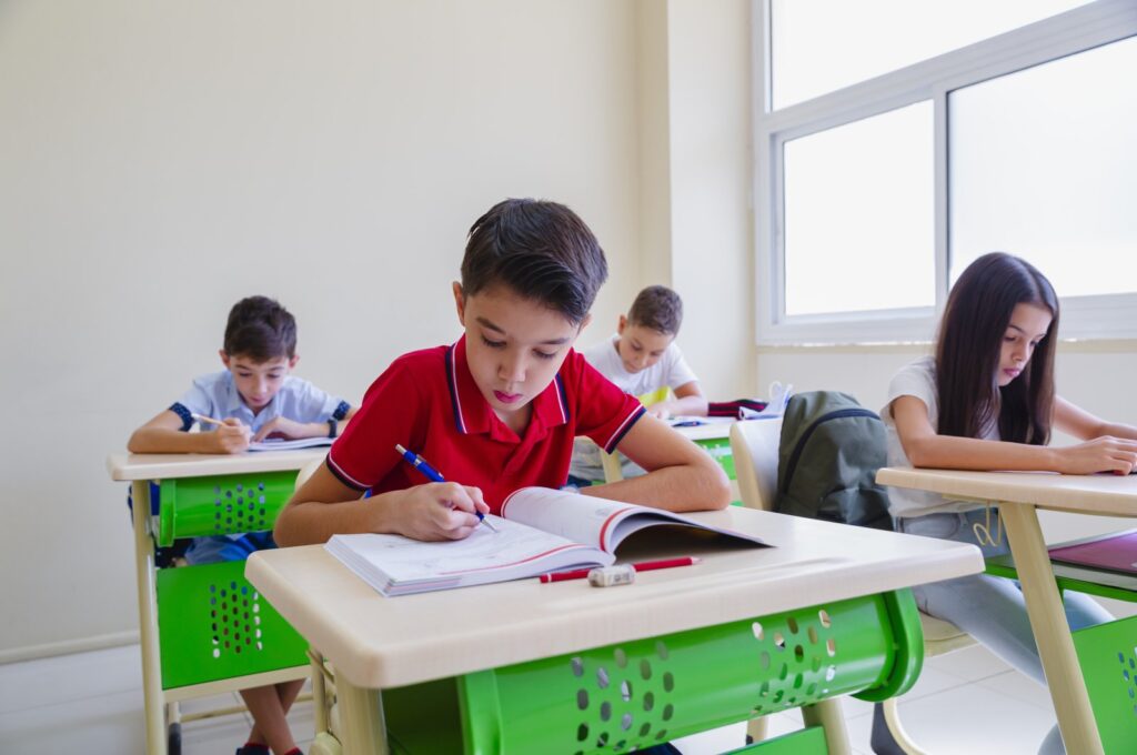 Group of students sitting and writing in a school classroom. (Getty Images)