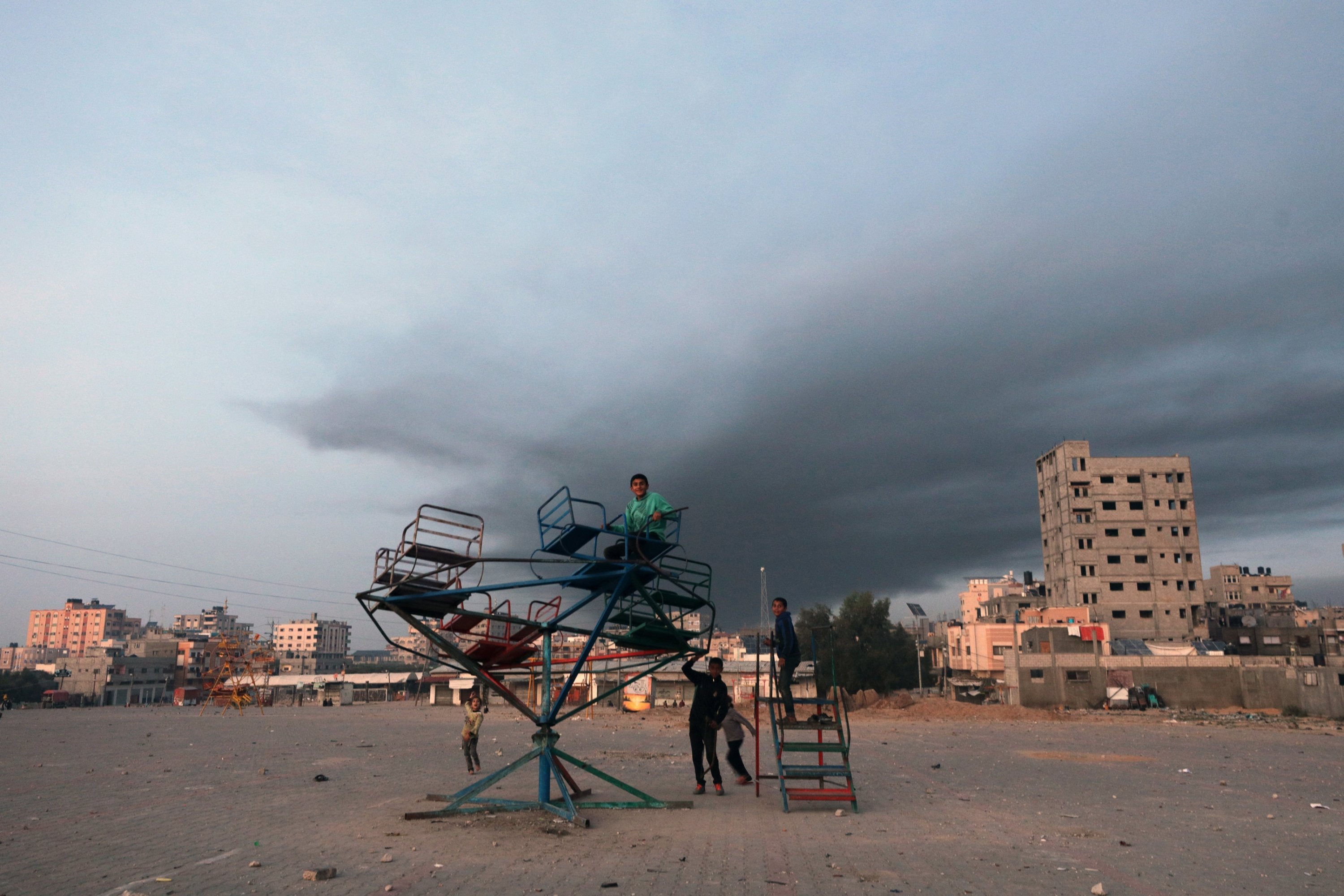 303827 Children play as smoke rises following Israeli airstrikes in the southern Gaza Strip, Palestine, Dec. 3, 2023. (EPA Photo)