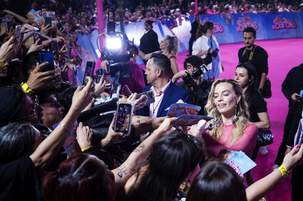 Australian actor Margot Robbie (R) signs autographs during the pink carpet event for the movie "Barbie," at Parque Toreo Central, in Mexico City, Mexico, July 6, 2023. (EPA Photo)