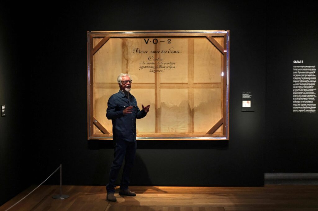 Miguel Angel Blanco, exhibition curator, gives some explanations about the back side of a painting called "Trompe l'oeil of the stretcher of Moses rescued from the Waters" by French artist Victor Orsel at the Prado Museum in Madrid, Spain, Dec. 5, 2023. (AFP Photo)
