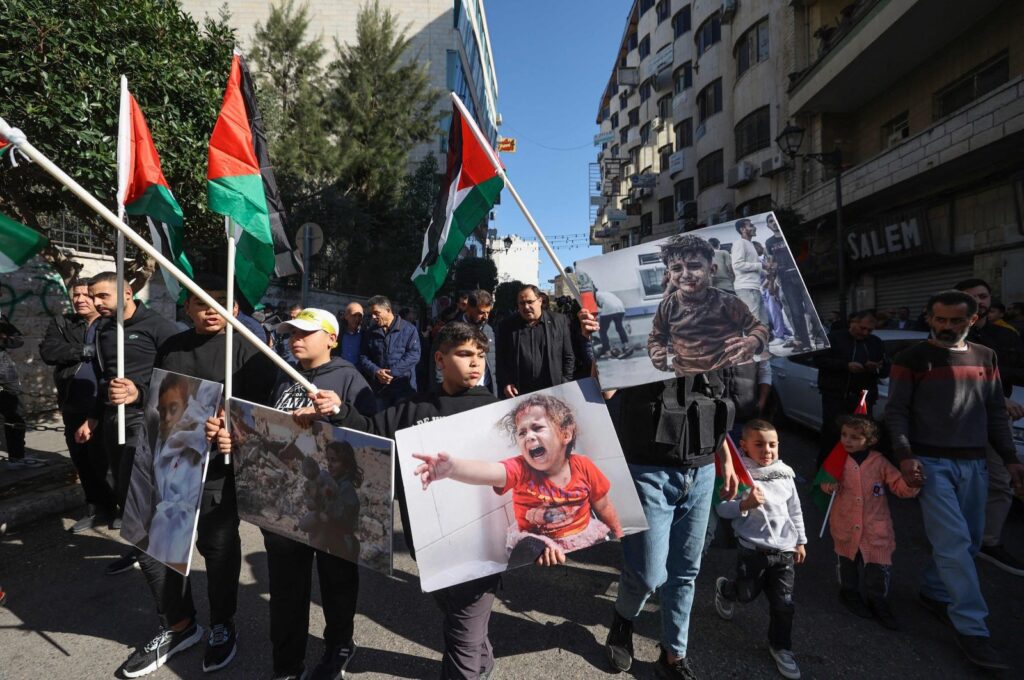 Palestinians lift national flags and chant slogans during a general strike in Ramallah, occupied West Bank, Palestine, Dec. 11, 2023. (AFP Photo)
