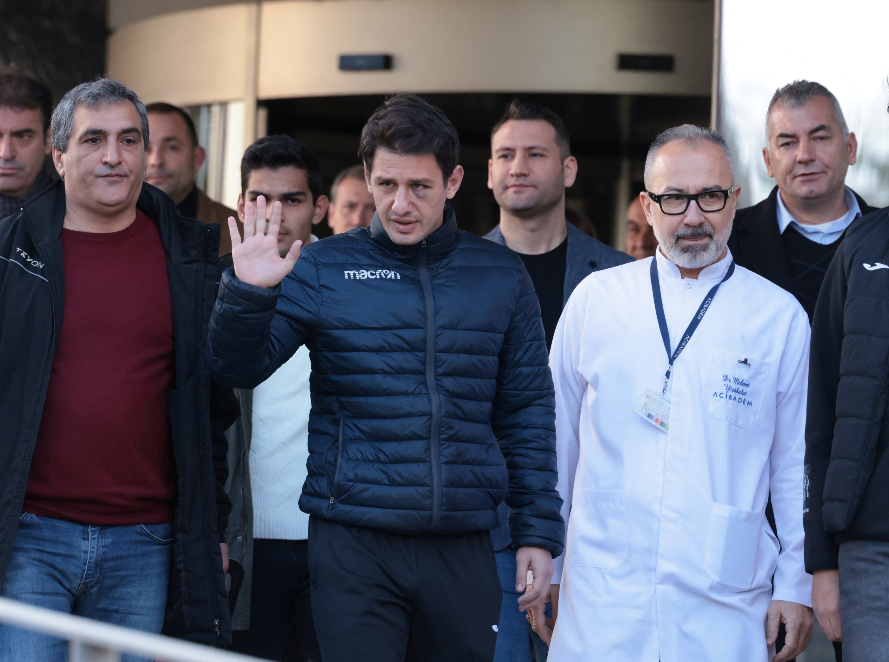 305300 Turkish referee Halil Umut Meler (C), accompanied by head doctor Mehmet Yorubulut, greets media members as he leaves from hospital, Ankara, Türkiye, Dec. 13, 2023. (Reuters Photo)
