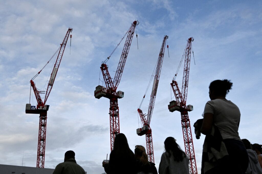 People walk past a construction site with cranes at Alexanderplatz, Berlin, Germany, Oct. 2, 2023. (Reuters Photo)