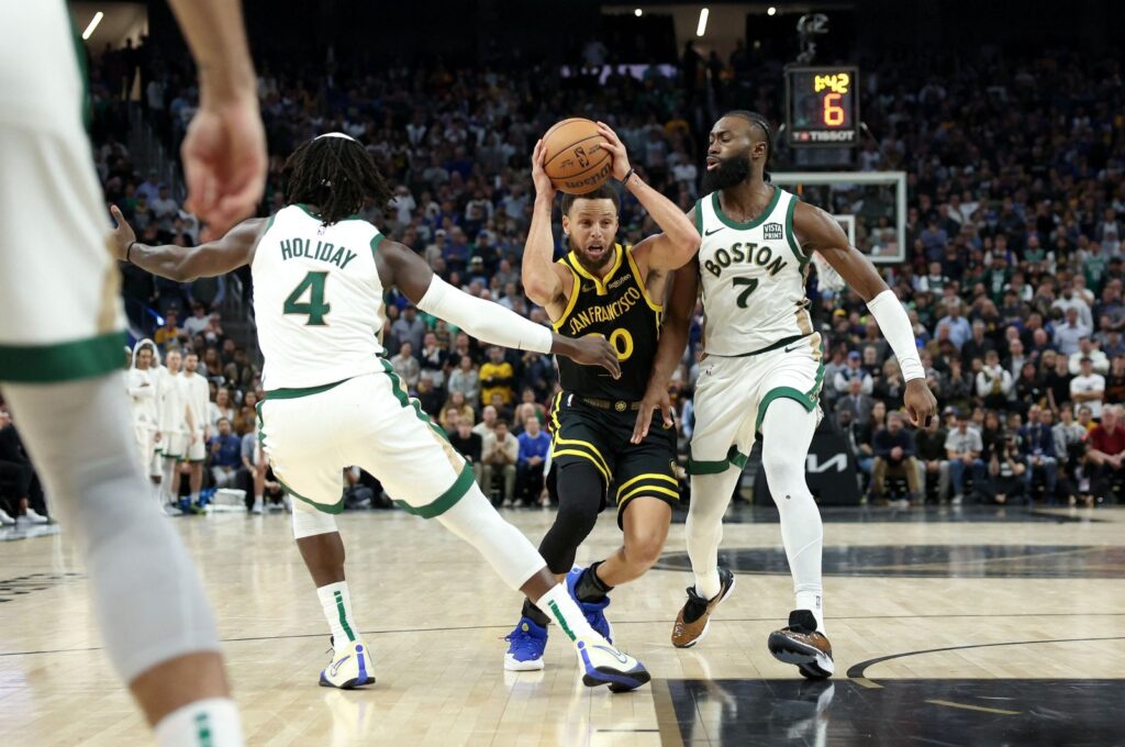 Golden State Warriors' Stephen Curry (C) is guarded by Boston Celtics' Jaylen Brown (R) at Chase Center, San Francisco, California, U.S., Dec. 19, 2023. (Getty Images Photo)