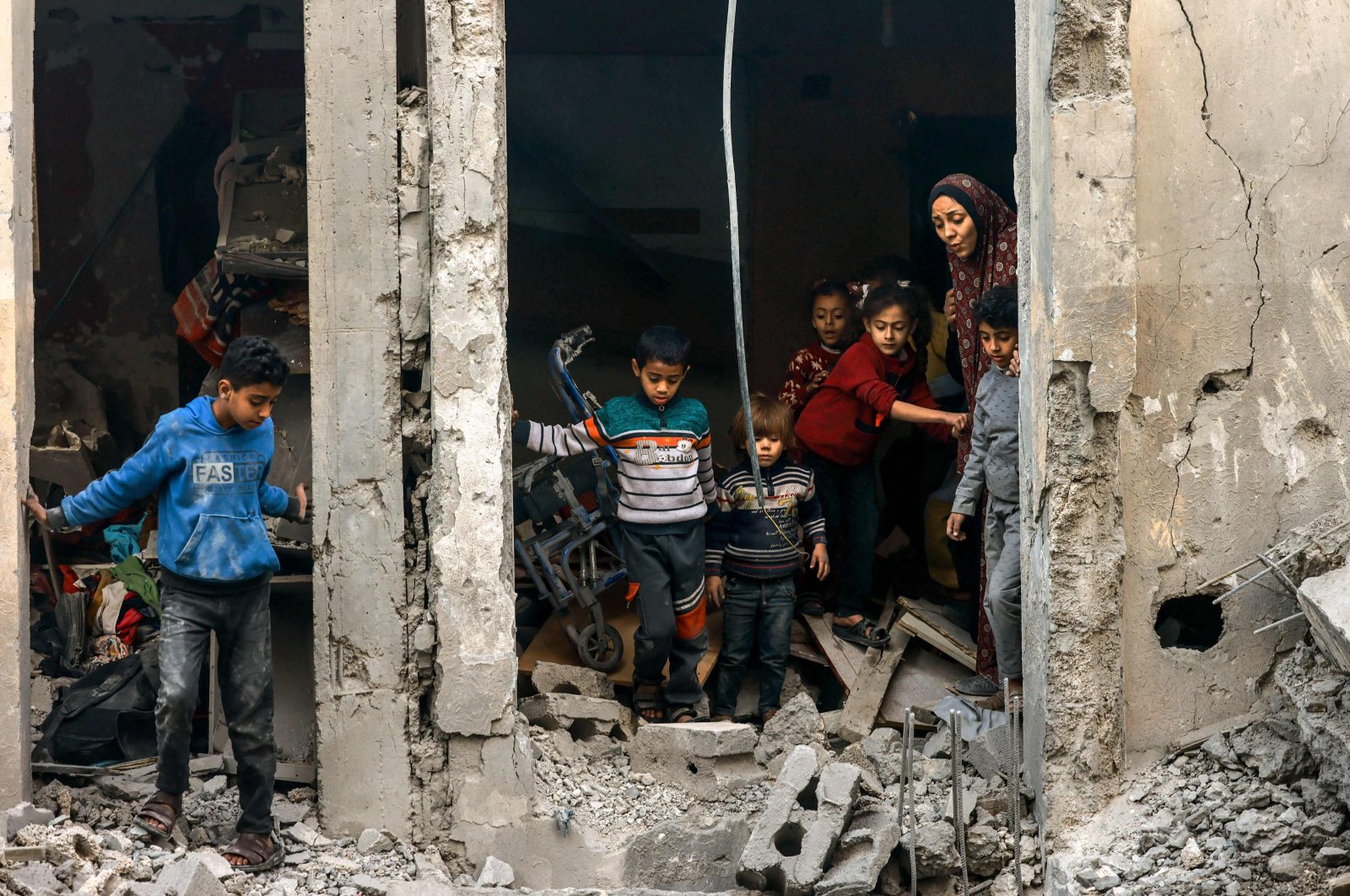 A Palestinian woman and children check debris following Israeli bombardment in Rafah, Gaza Strip, Palestine, Dec. 22, 2023. (AFP Photo)