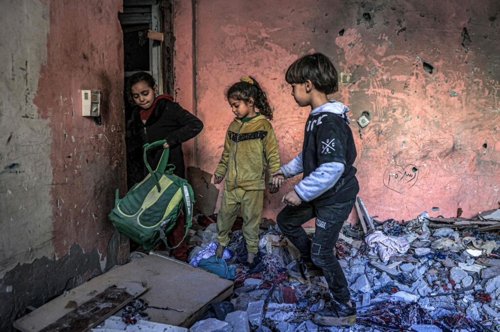 Children inspect items in the rubble in a room overlooking a building destroyed by Israeli bombardment, Rafah, southern Gaza Strip, Palestine, Dec. 24, 2023. (AFP Photo)