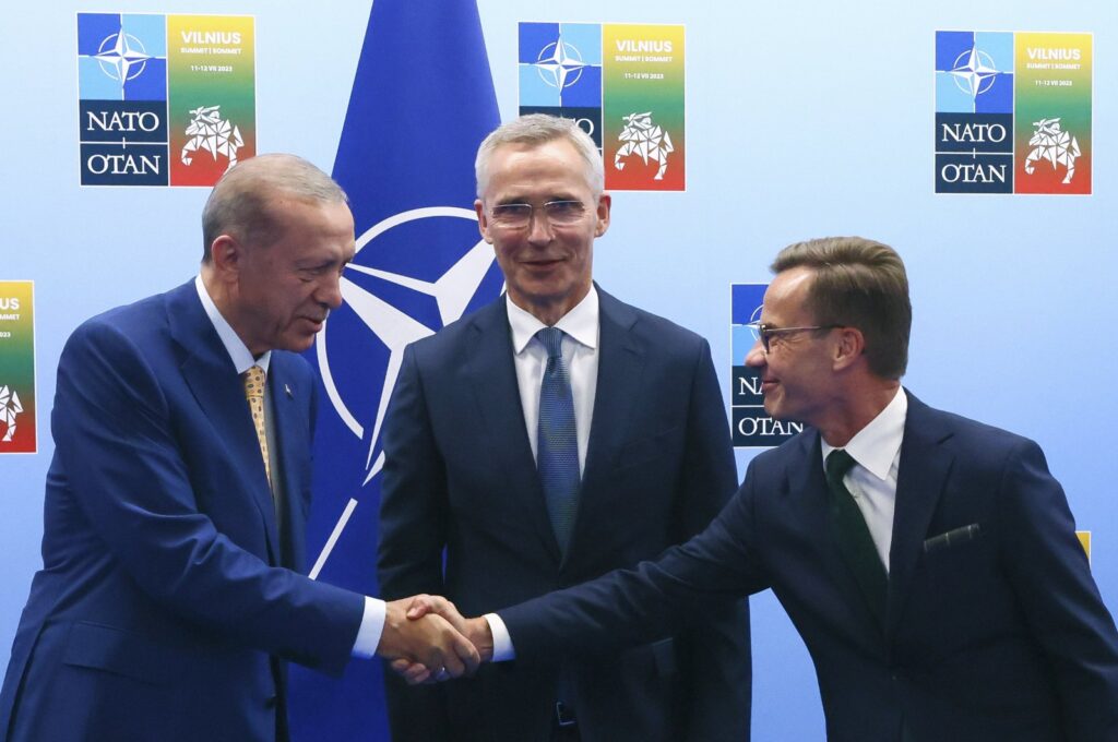 President Recep Tayyip Erdoğan (L) shakes hands with Sweden's Prime Minister Ulf Kristersson (R) as NATO Secretary-General Jens Stoltenberg (C) looks on prior to a meeting ahead of a NATO summit in Vilnius, Lithuania, July 10, 2023. (AP Photo)