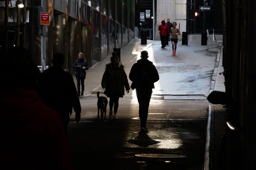 People walk through the Financial District by the New York Stock Exchange (NYSE) on the last day of trading for the year, in New York City, U.S., Dec. 29, 2023. (AFP Photo)