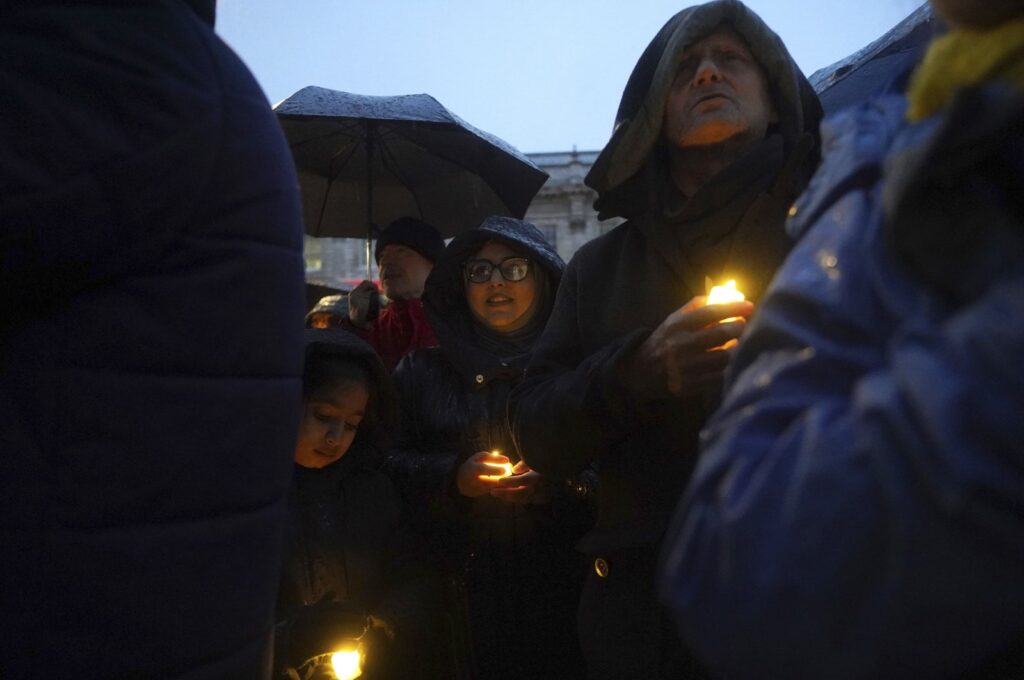 People hold candles during a anti-hate vigil on Whitehall, London, Dec. 3, 2023. (AP Photo)