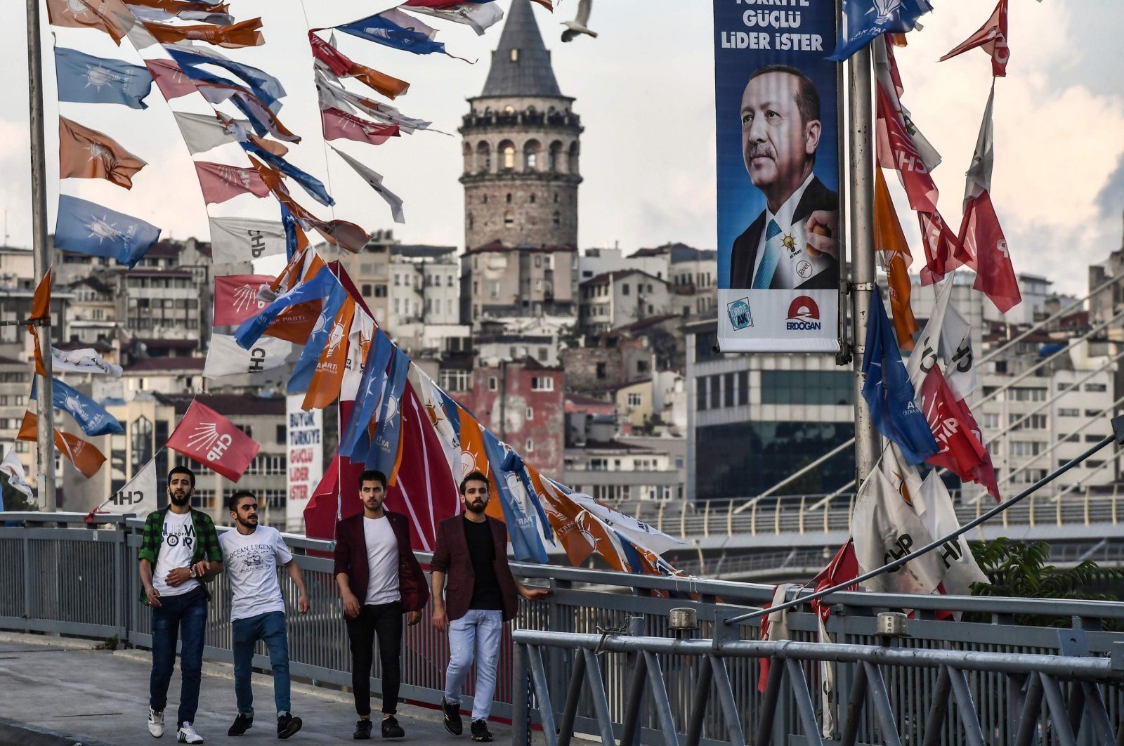 People pass by banners with the portrait of President Recep Tayyip Erdoğan in Istanbul, Türkiye, June 18, 2018. (AFP File Photo)