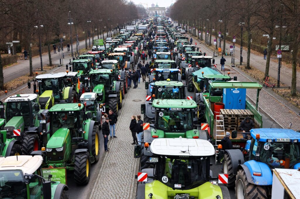 People stand beside tractors, as German farmers take part in a protest against the cut of vehicle tax subsidies, near the Brandenburg Gate in Berlin, Germany, Dec. 18, 2023. (Reuters Photo)