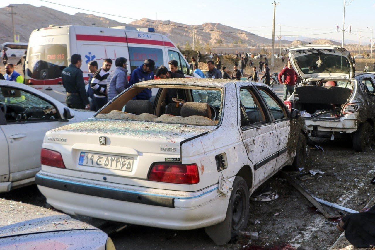 Damaged cars are seen as people try to help victims after an explosion next to the tomb of Iran's Revolutionary Guards chief of foreign operations in the Saheb al-Zaman mosque in the southern city of Kerman, Iran, Jan. 3, 2024. (EPA Photo)