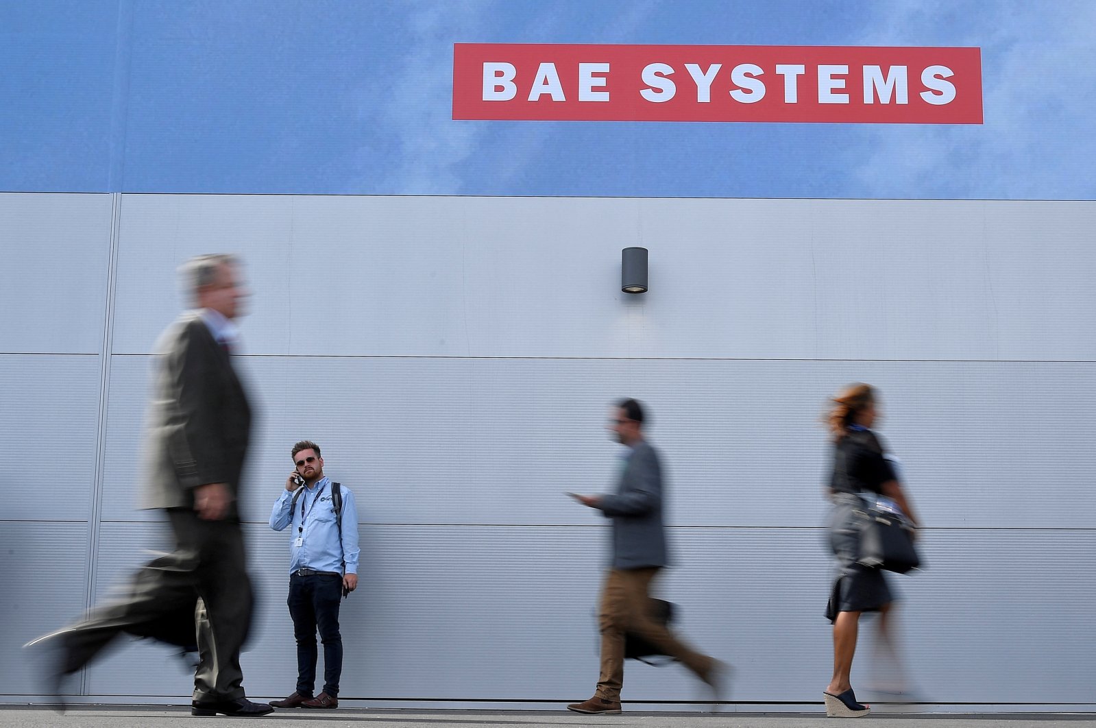 Trade visitors walk past an advertisement for BAE Systems at Farnborough International Airshow in Farnborough, U.K., July 17, 2018. (Reuters Photo)