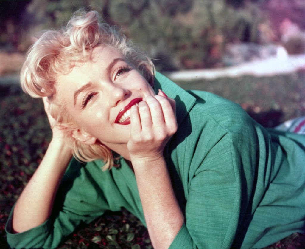 American actor Marilyn Monroe poses for a portrait laying on the grass in 1954 in Palm Springs, California. (Getty Images Photo)
