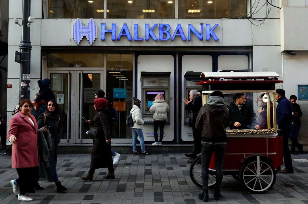 People walk past by a branch of Halkbank in central Istanbul, Türkiye, Jan. 22, 2020.