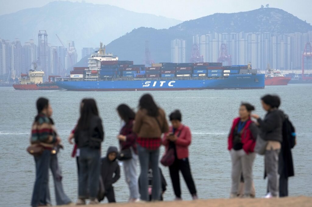 A container ship passes tourists in Xiamen in southeast China's Fujian province, Dec. 26, 2023. (AP Photo)