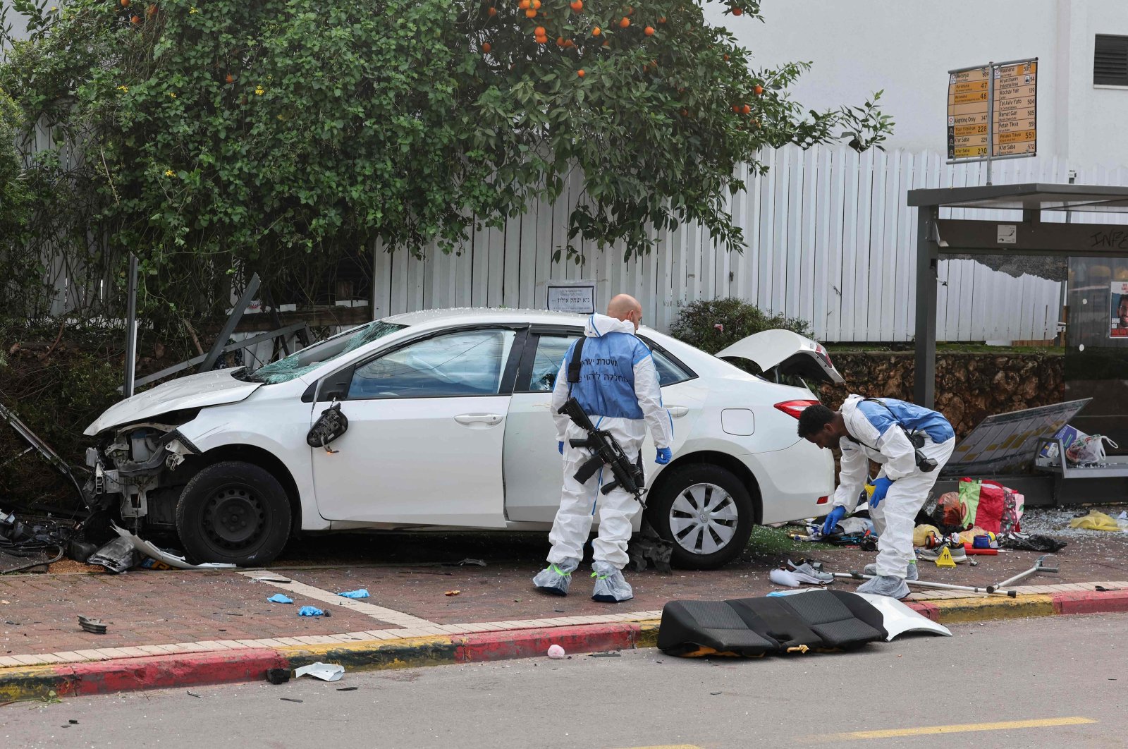 Israeli police forensics personnel inspect a damaged car in the central town of Raanana, Israel, Jan. 15, 2024. (AFP Photo)