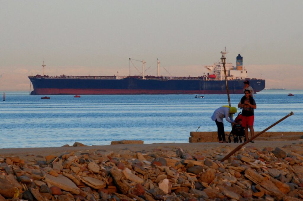 People walk on a beach as a container ship crosses the Gulf of Suez toward the Red Sea before entering the Suez Canal, in al-Ain al-Sokhna, Suez, east of Cairo, Egypt, April 24, 2017. (Reuters Photo)