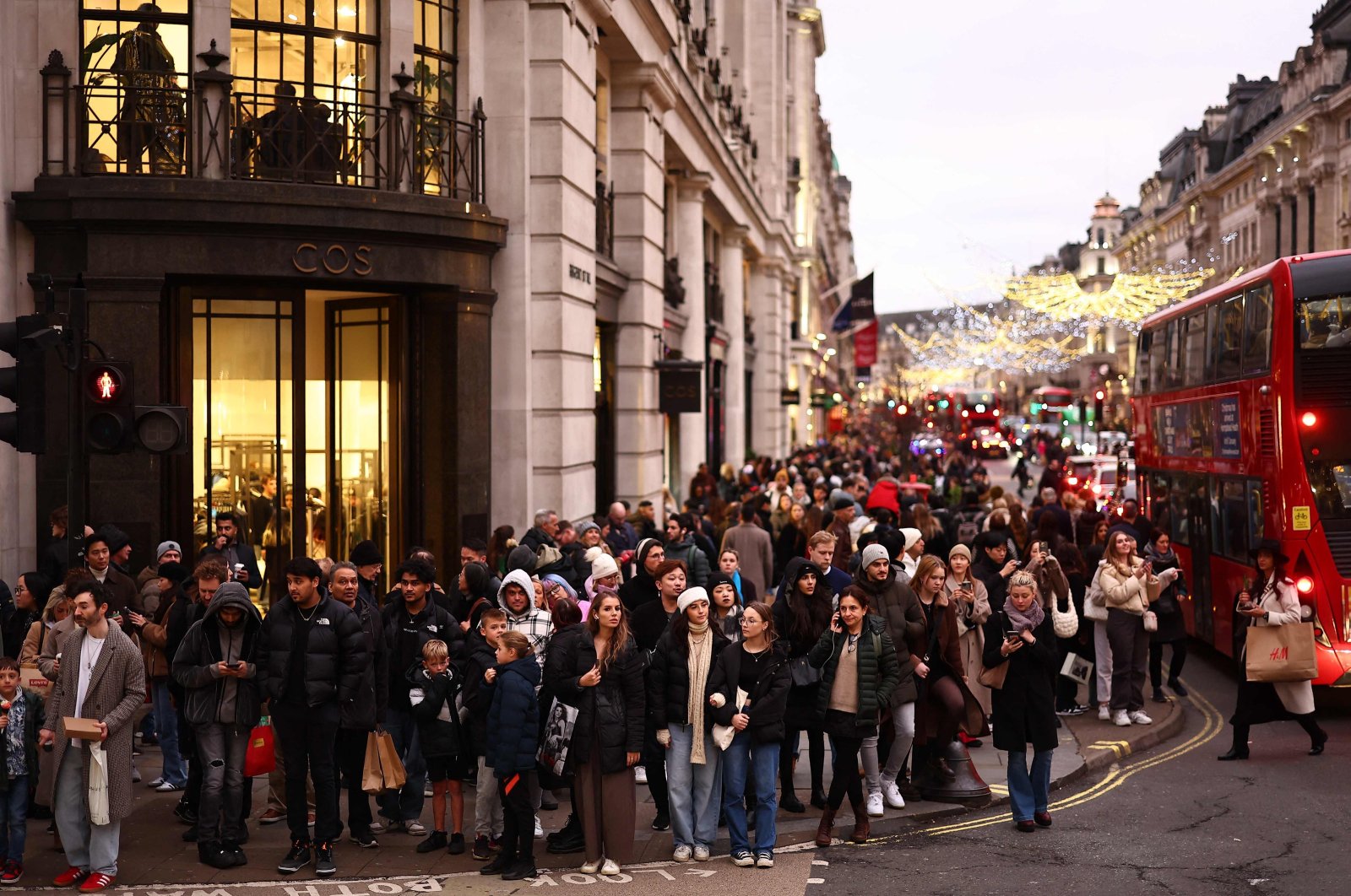Shoppers wait to cross a side road beside shops on Regent Street in London, U.K., Dec. 22, 2023. (AFP Photo)