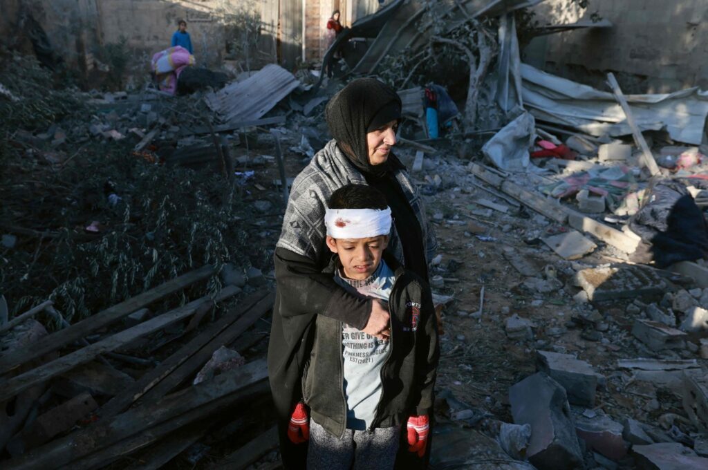 A Palestinian woman embraces a lightly injured boy as they check the rubble of a building following Israeli bombardment, Rafah, southern Gaza Strip, Palestine, Jan. 18, 2024. (AFP Photo)